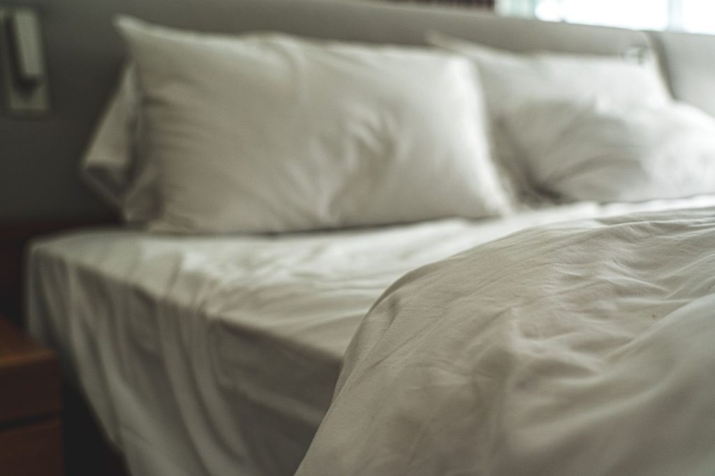 pexels-photo-3755590 Elegant white bed linen with soft pillows creating a warm and inviting atmosphere.